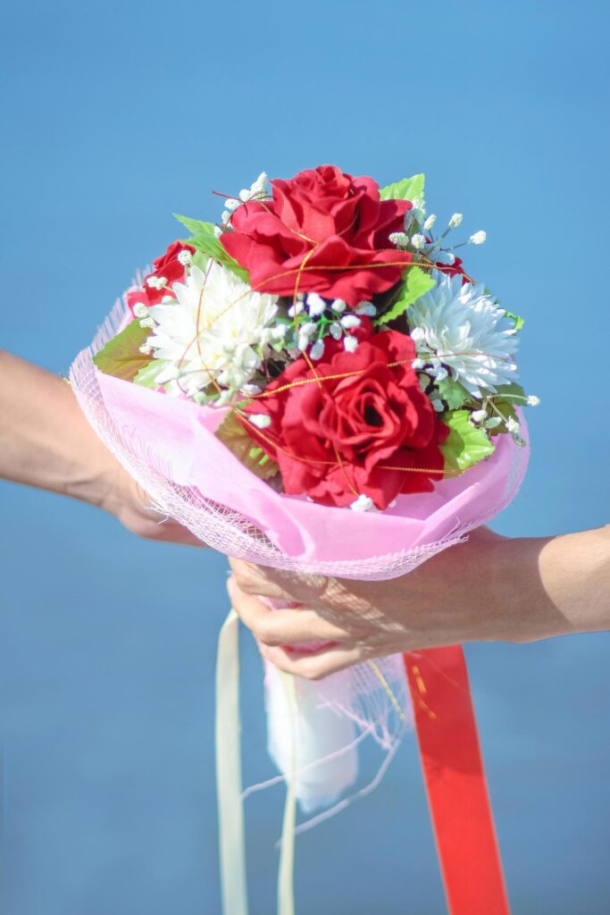 Couple love hand holding Beautiful Roses Flowers bouquet. Valentine day and wedding ceremony concept Stock Free