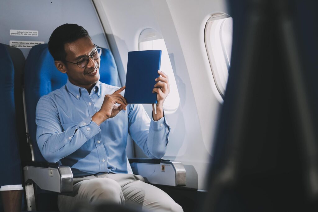 Airplane, travel and portrait of businessman working on laptop computer and smartphone while sitting in airplane. Stock Free