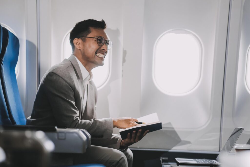 Airplane, travel and portrait of businessman working on laptop computer and smartphone while sitting in airplane. Stock Free