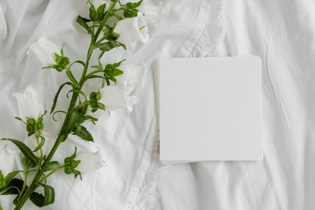 Mockup photo – white bedding – flowers – blank sheet – square Stock Free