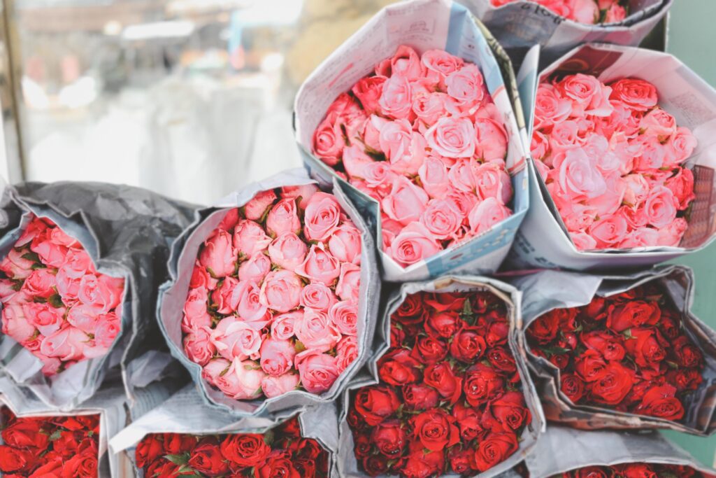 Colorful beautiful rose wrapped in paper on sale at flower market, present gift on Valentine’s day. Stock Free