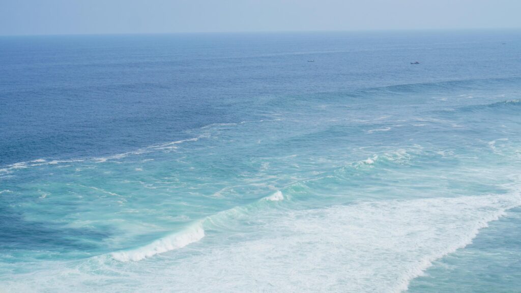 Front view over the ocean and white foam waves. Feel calm, cool, relaxed. Idea for cool background and copy space above. Stock Free