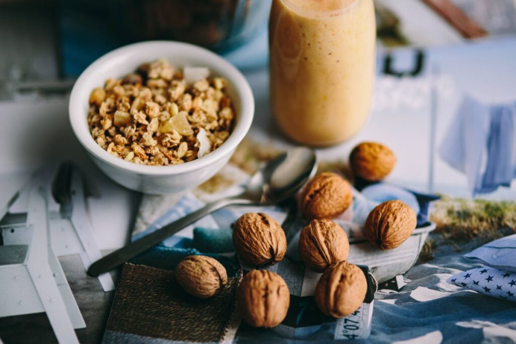 Jar full of walnuts with a fresh healthy shake and musli in a bowl Stock Free