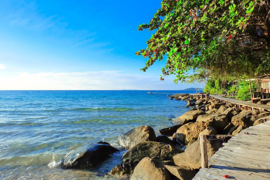 Wooden bridge walkway with rocky coast. sky and cloud natural background on vacation and relax time. Stock Free