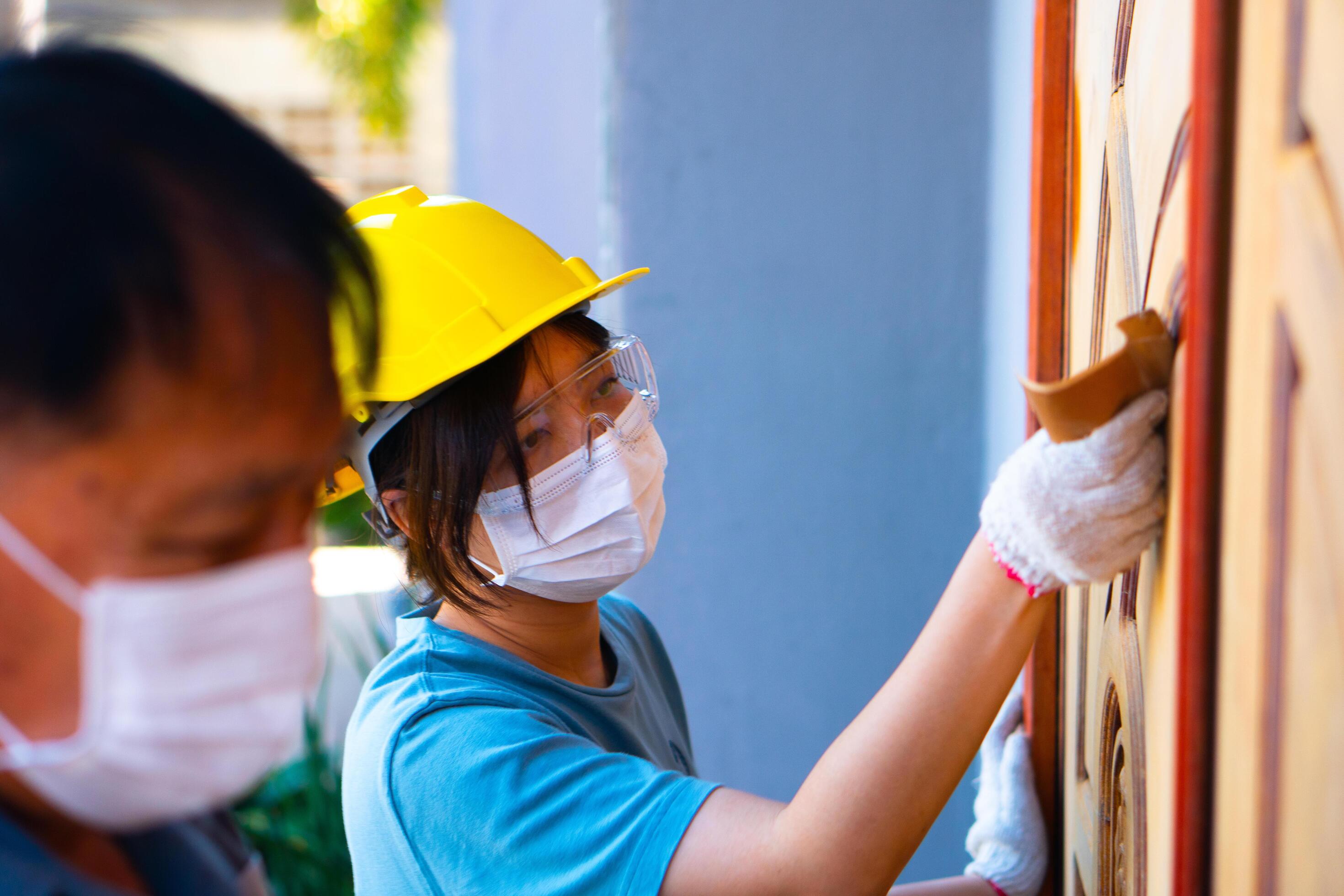 A team family worker Using sandpaper to polish a wooden door at home. Stock Free