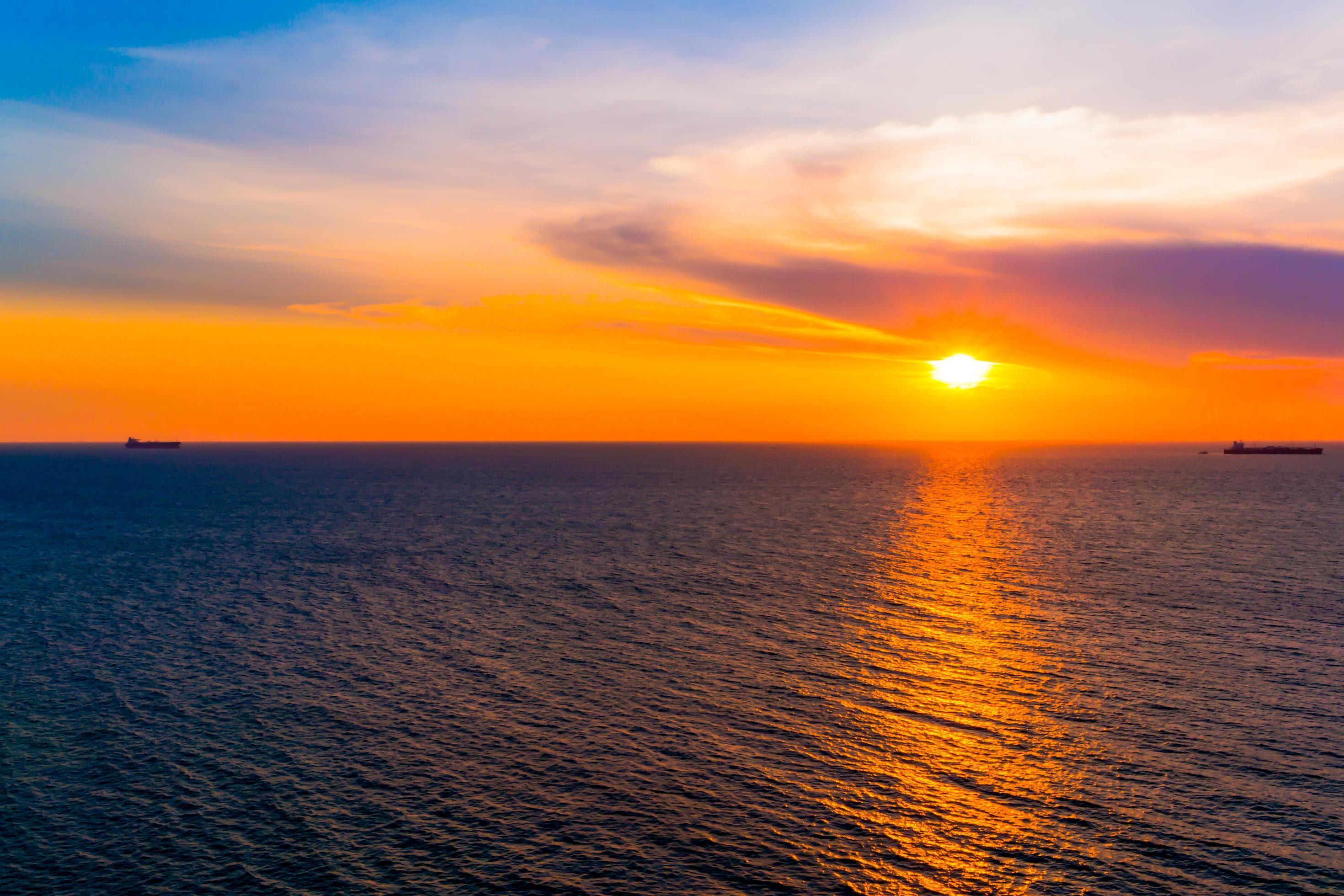 Colorfull sunset on the sea of Silhoutte Cargo Ship nature background Stock Free