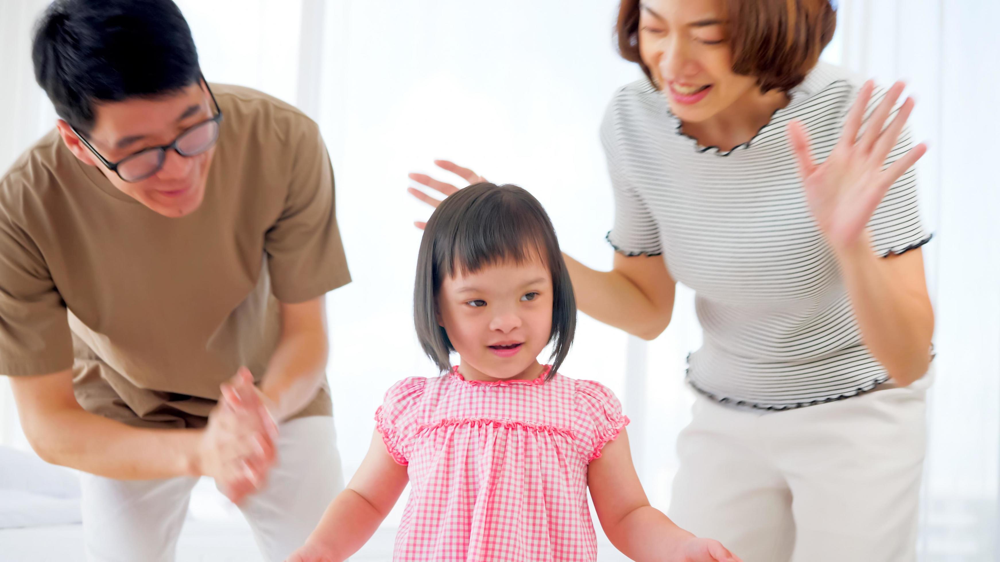 Happy family with mother, father and disabled daughter spending time together at home. Stock Free