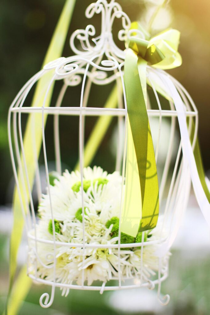 White birdcage decoration with roses and white flowers hanging decoration in garden for wedding ceremony Stock Free