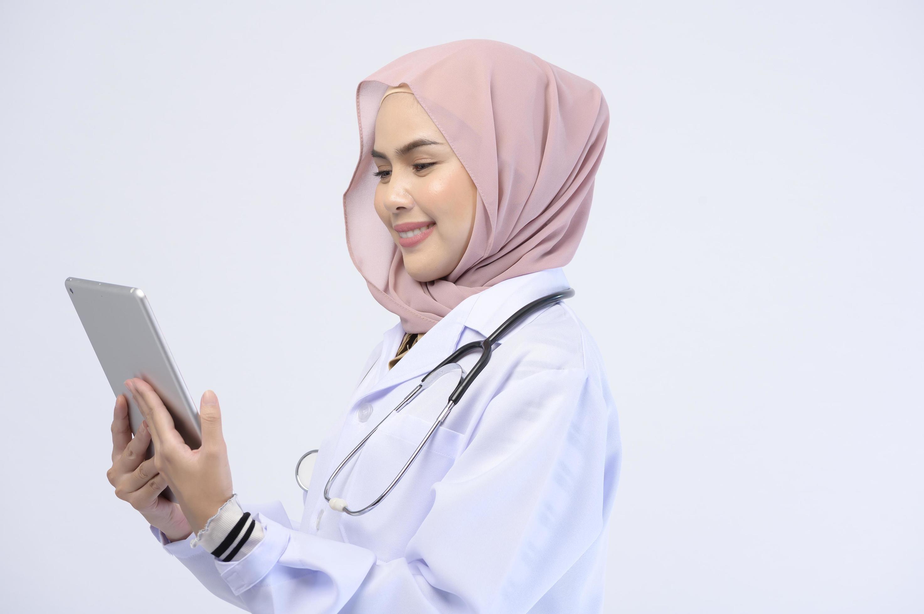 Female muslim doctor with hijab over white background studio. Stock Free