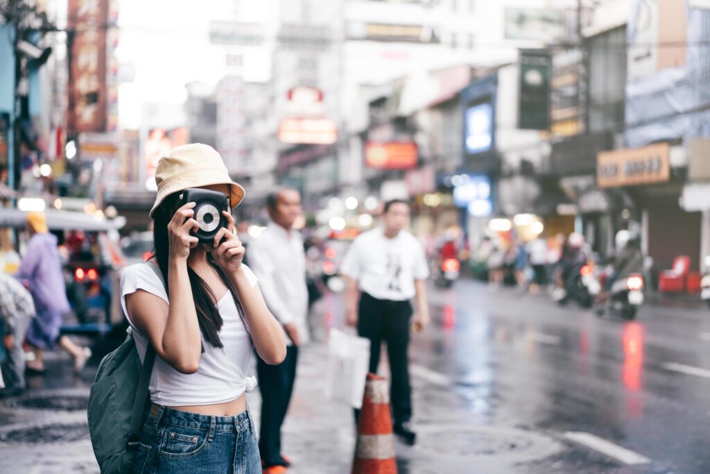 vintage style asian woman with instant camera in Bangkok, Thailand Stock Free