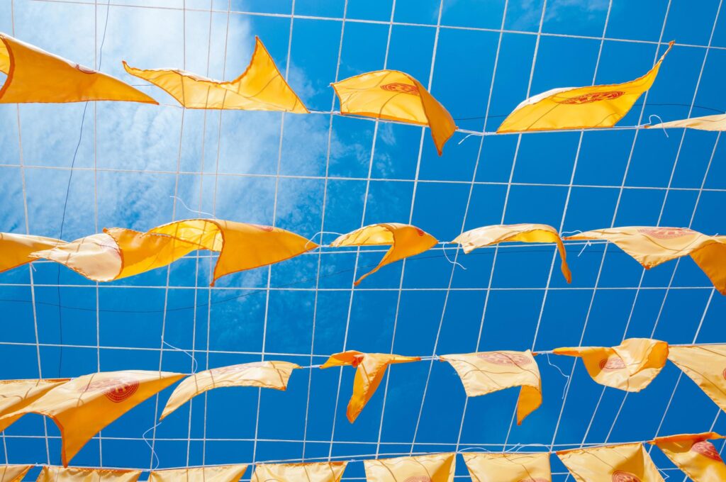 Thammachak flag yellow in temple Wat Phan tao on blue sky temple Northern Thailand Stock Free