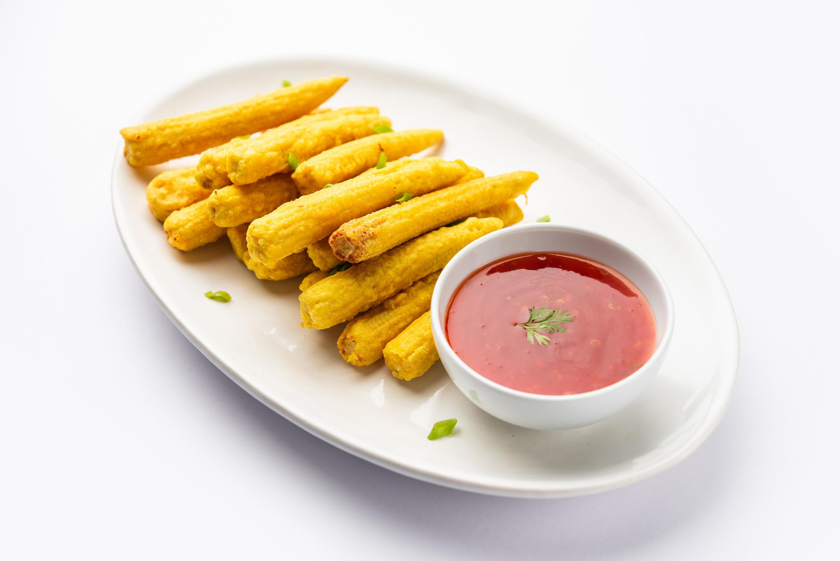 Crispy fried baby corn pakoda, pakora or Baby corn fritters served with ketchup, Indian food Stock Free