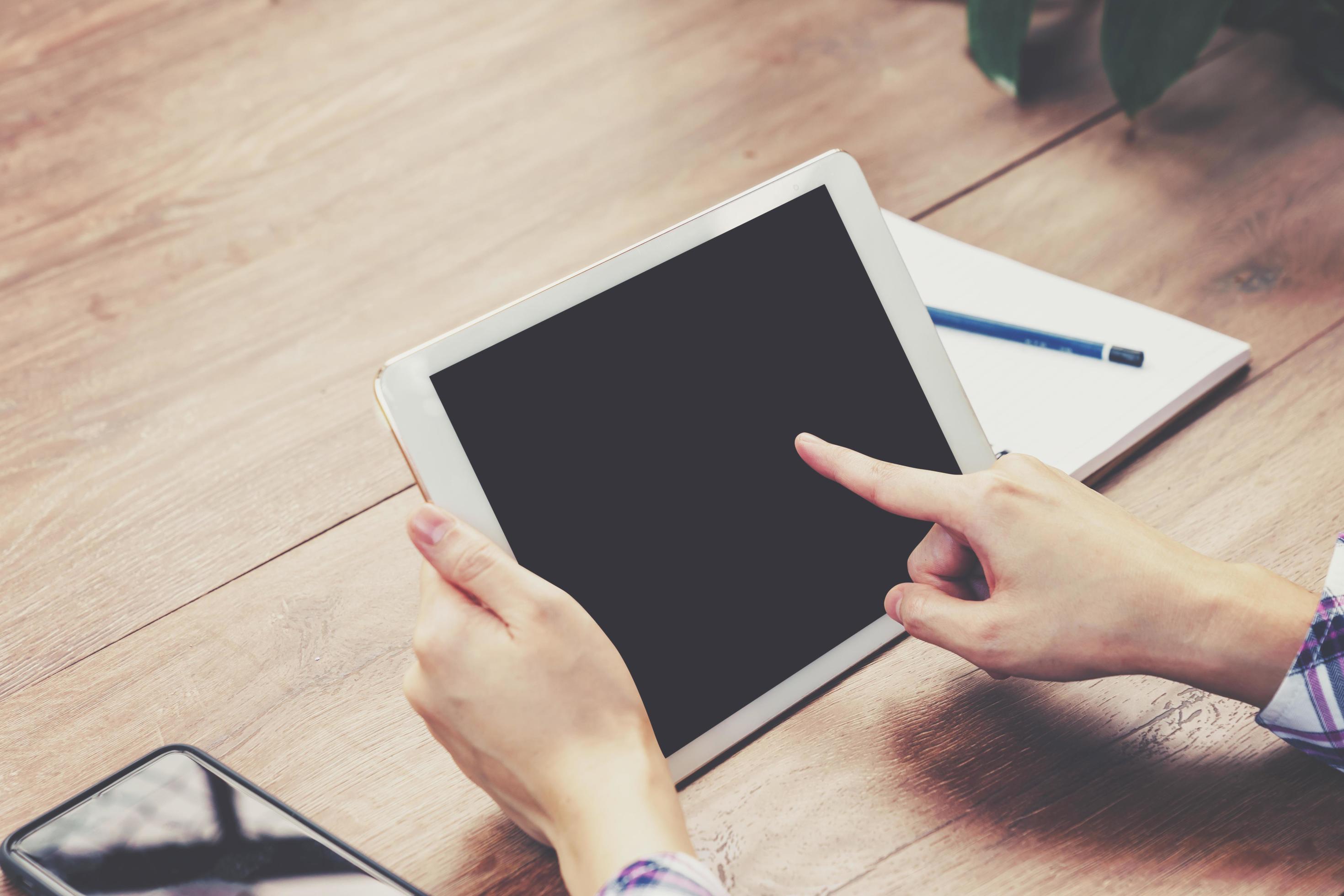 Hand woman using tablet computer on wooden table with Vintage toned. Stock Free