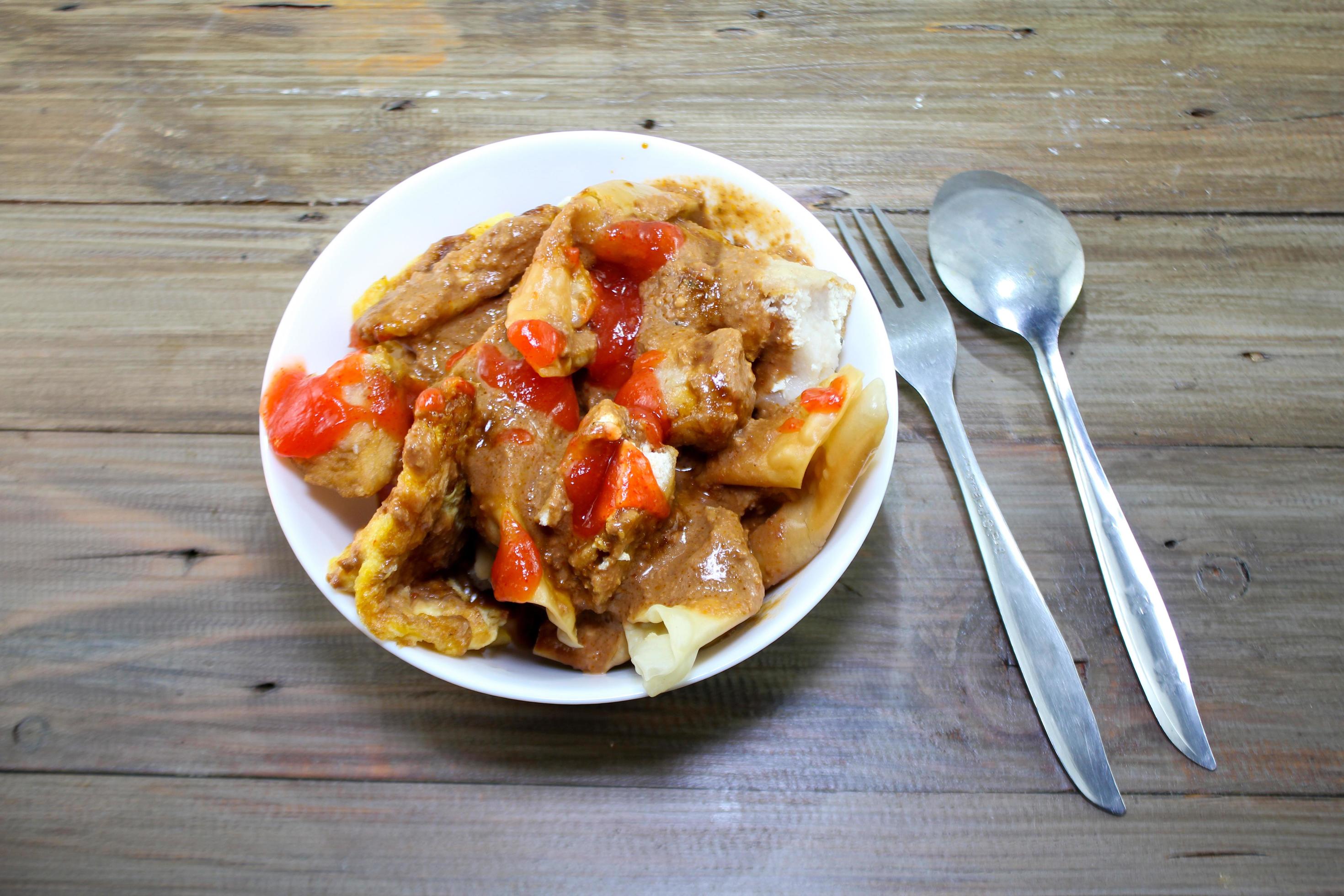 fried batagor on a white bowl. batagor is an Indonesian snack food, usually enjoyed with the addition of peanut sauce, soy sauce and chili sauce. Stock Free