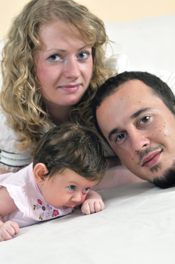 indoor portrait with happy young family and cute little babby Stock Free