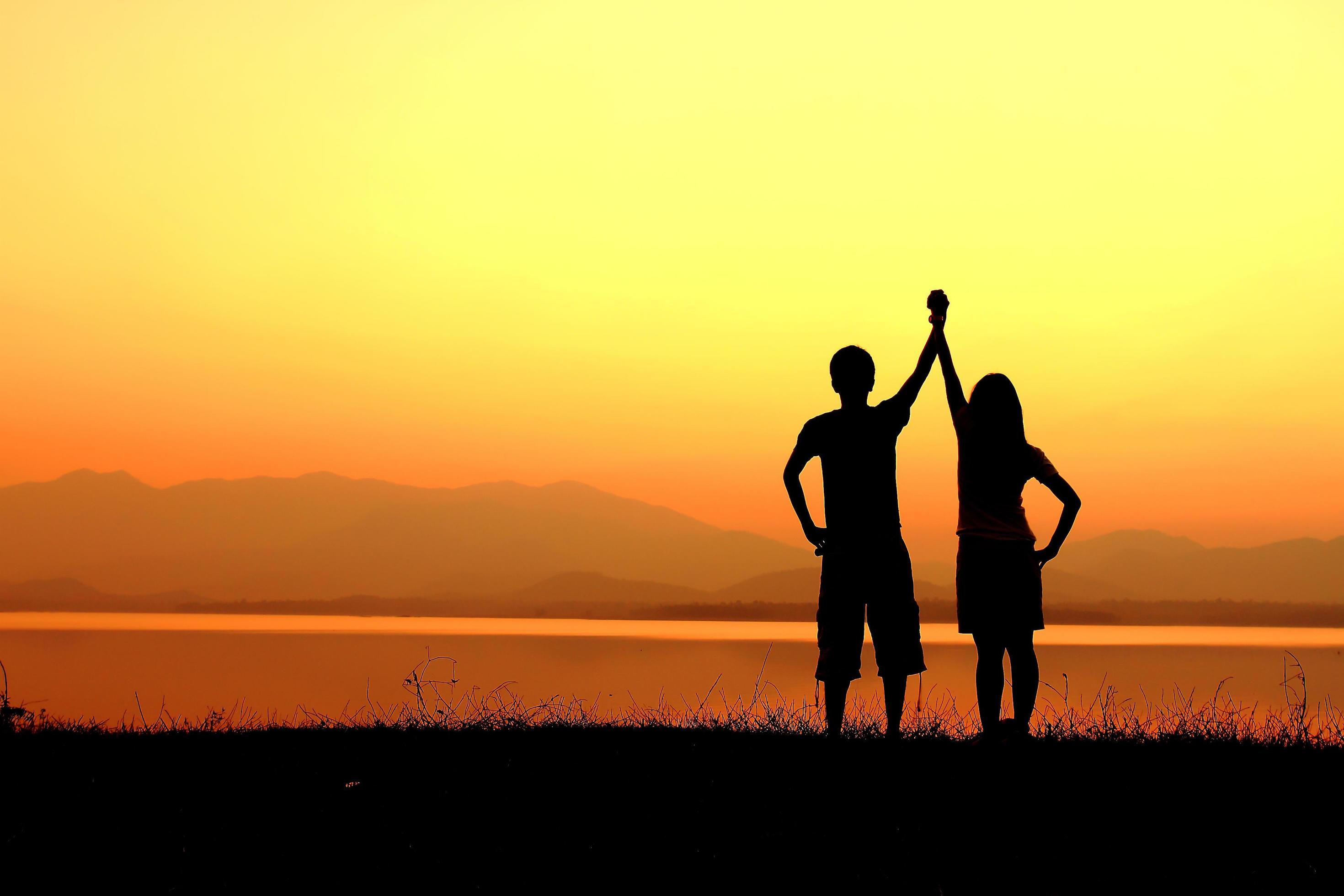 Couple silhouette on the beach at sunset Stock Free