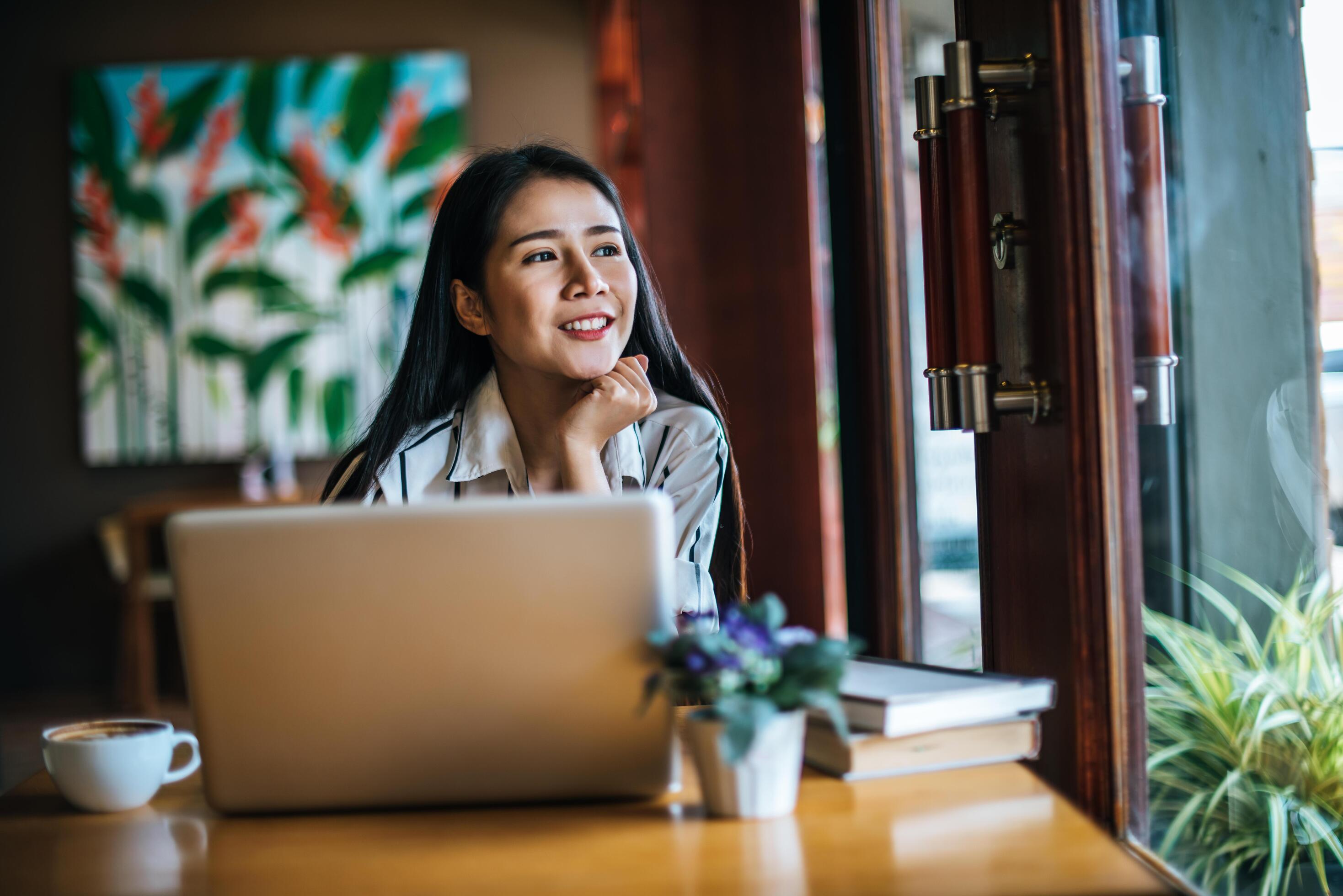 Beautiful woman working with laptop computer at coffee shop cafe Stock Free