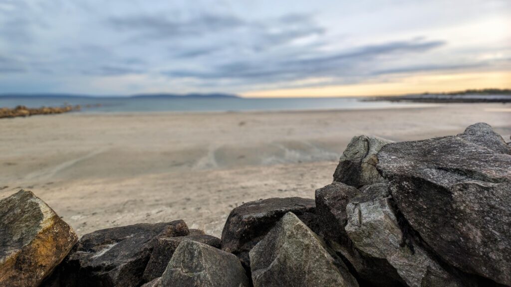 Costal landscape, focus on rocks in foreground, blurred background, sunset beach scenery, nature Stock Free