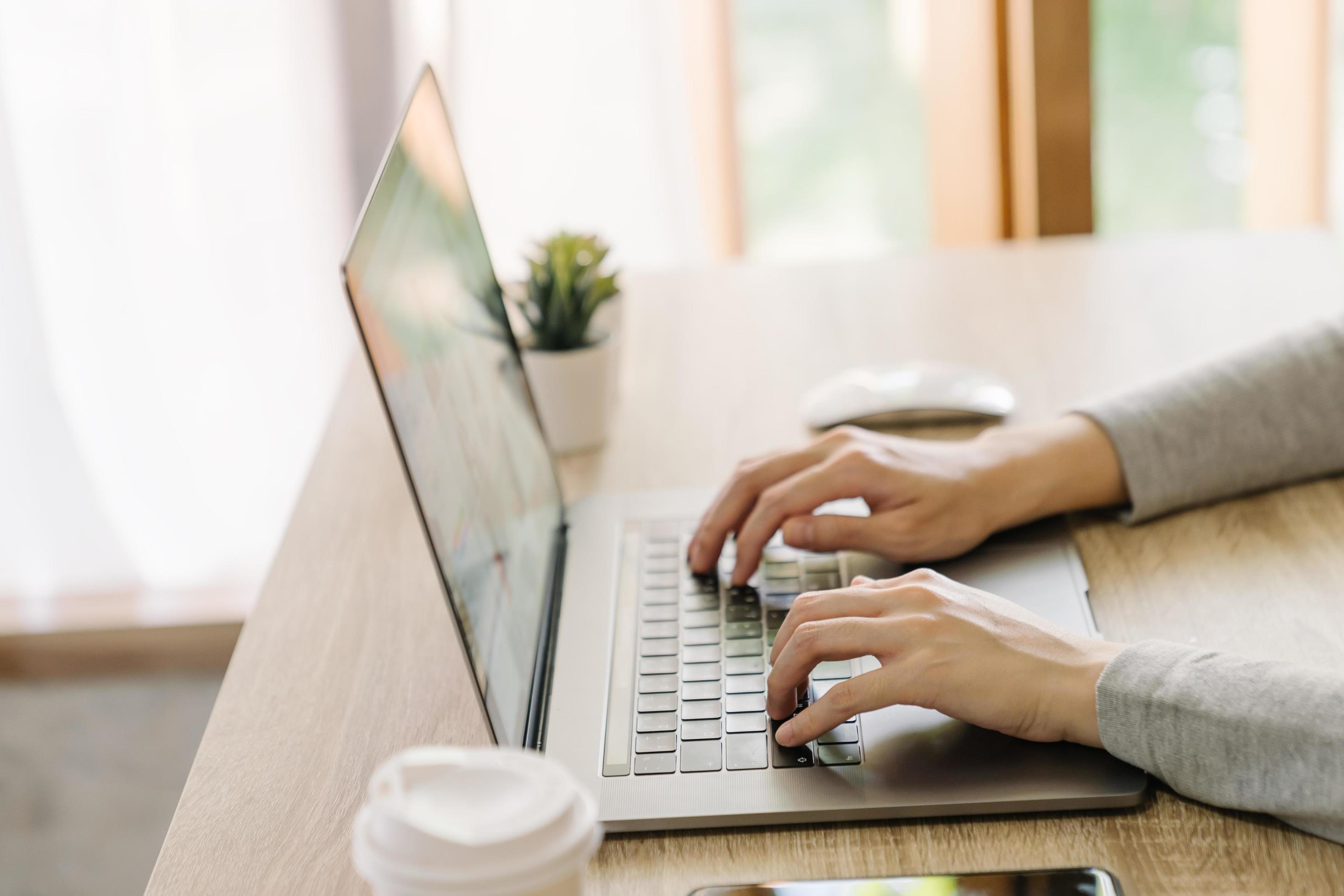 Business woman hand typing laptop computer on wooden table Stock Free