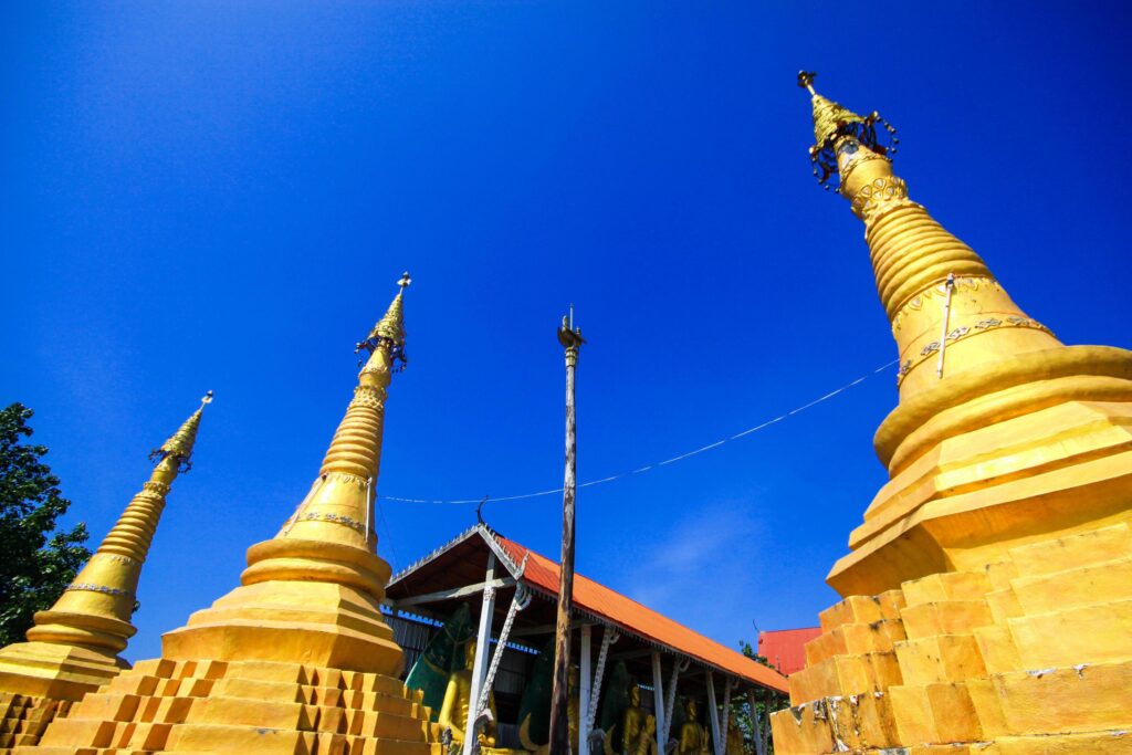 Golden pagoda detail is Mon architectural style at temple located in Kanchanaburi Province, Thailand. Stock Free