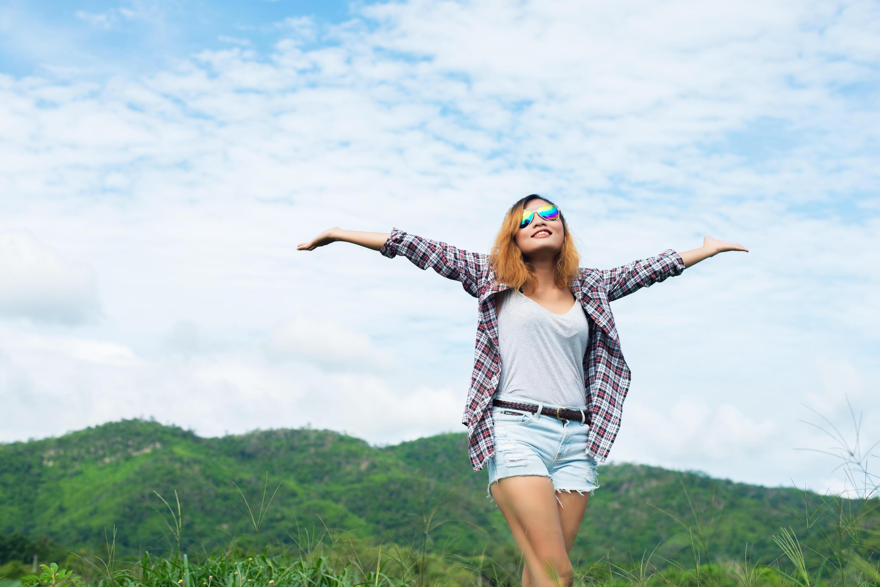 Young beautiful woman enjoying freedom and life in nature behind the mountain. Stock Free