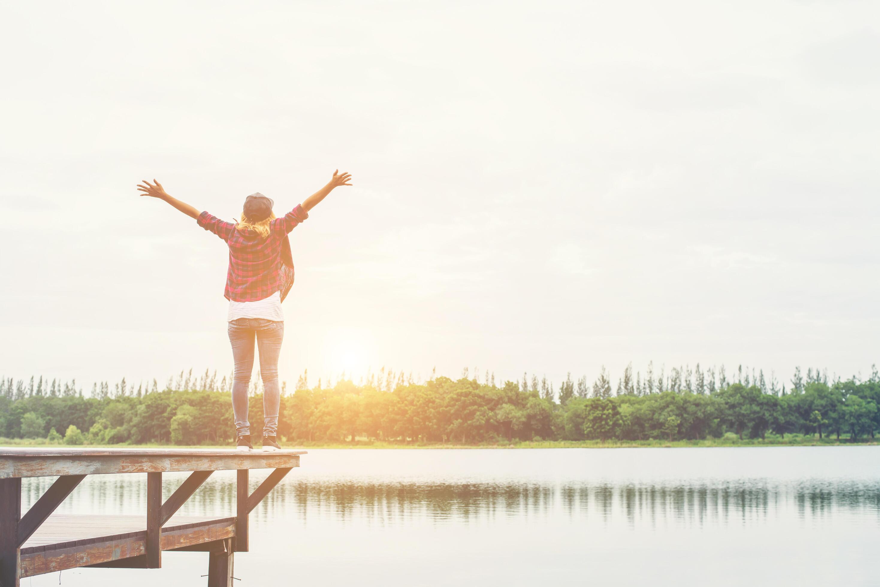 Happy hipster woman enjoying leisure at the pier lake,relaxing enjoy with natural. Stock Free