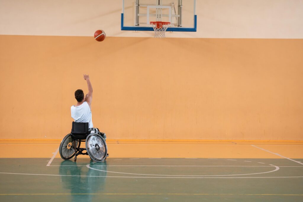 a photo of a war veteran playing basketball with a team in a modern sports arena. The concept of sport for people with disabilities Stock Free