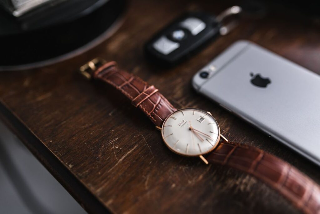 Apple iPhone 6 and Vintage watch on a brown leather wallet Stock Free