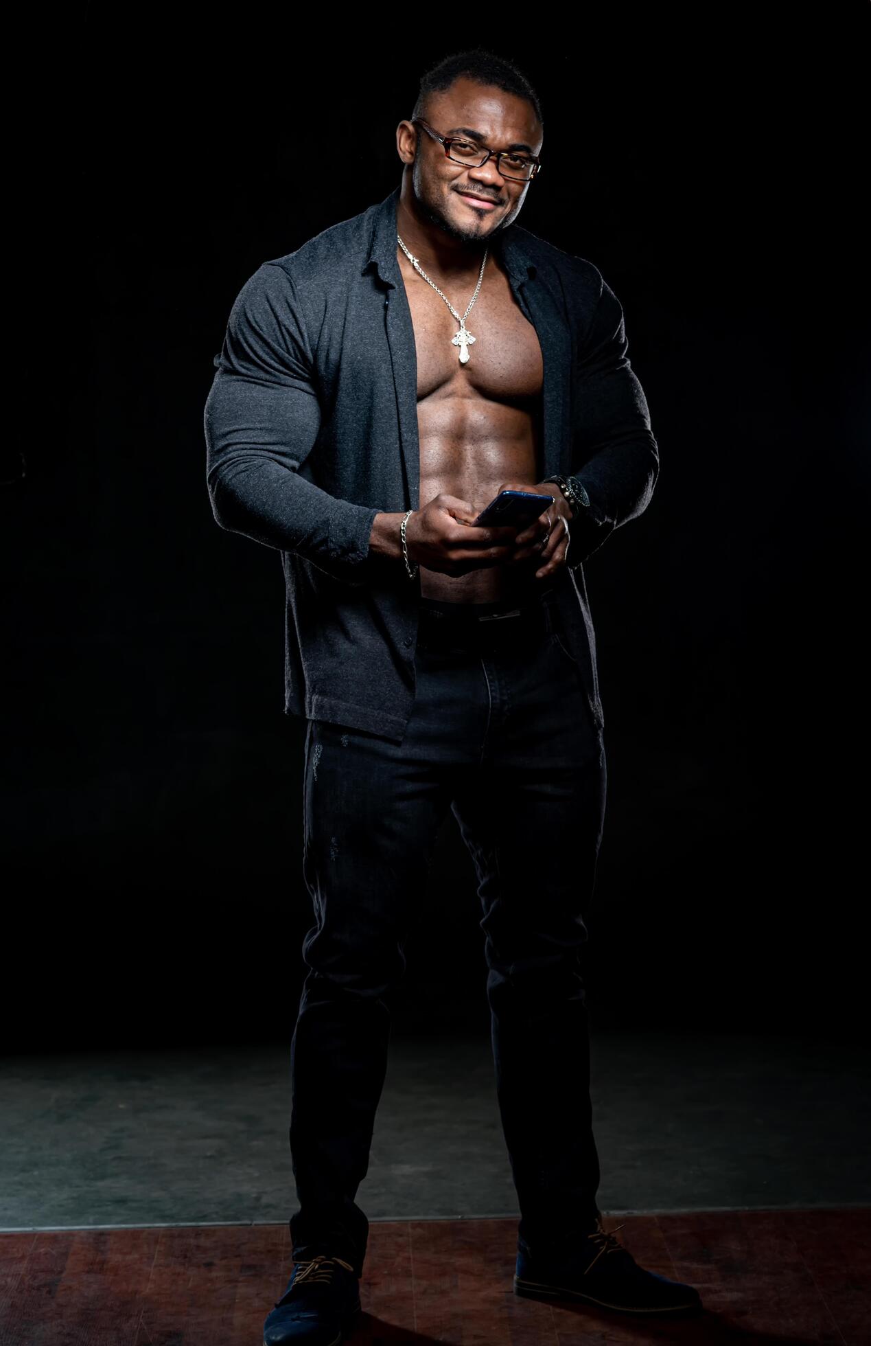 Young strong macho. Sexy shirtless muscular man on dark background. Stock Free