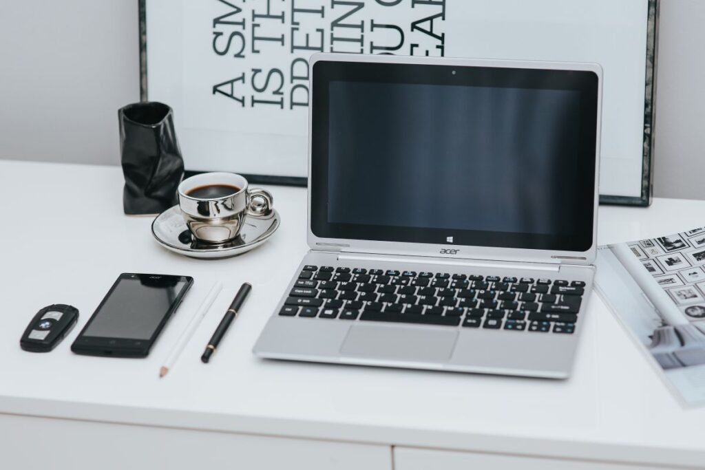 Laptop computer on white desk Stock Free