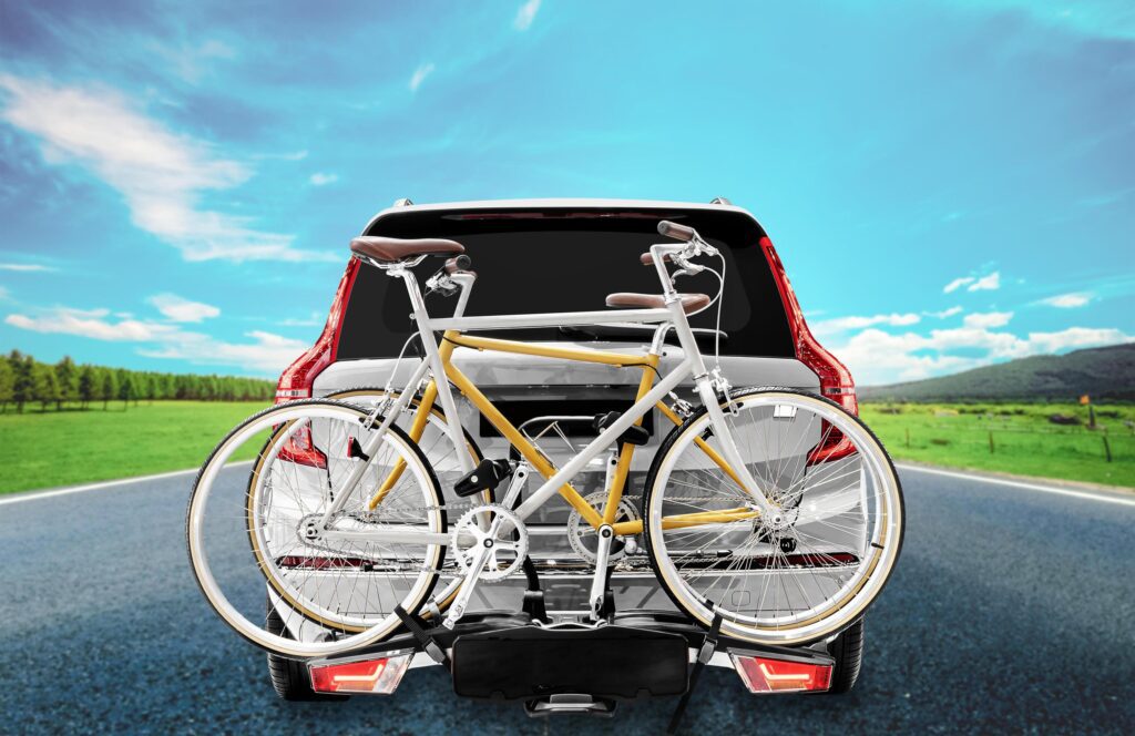 Back view gray suv car and bicycle on the rear rack with highway road view background Stock Free