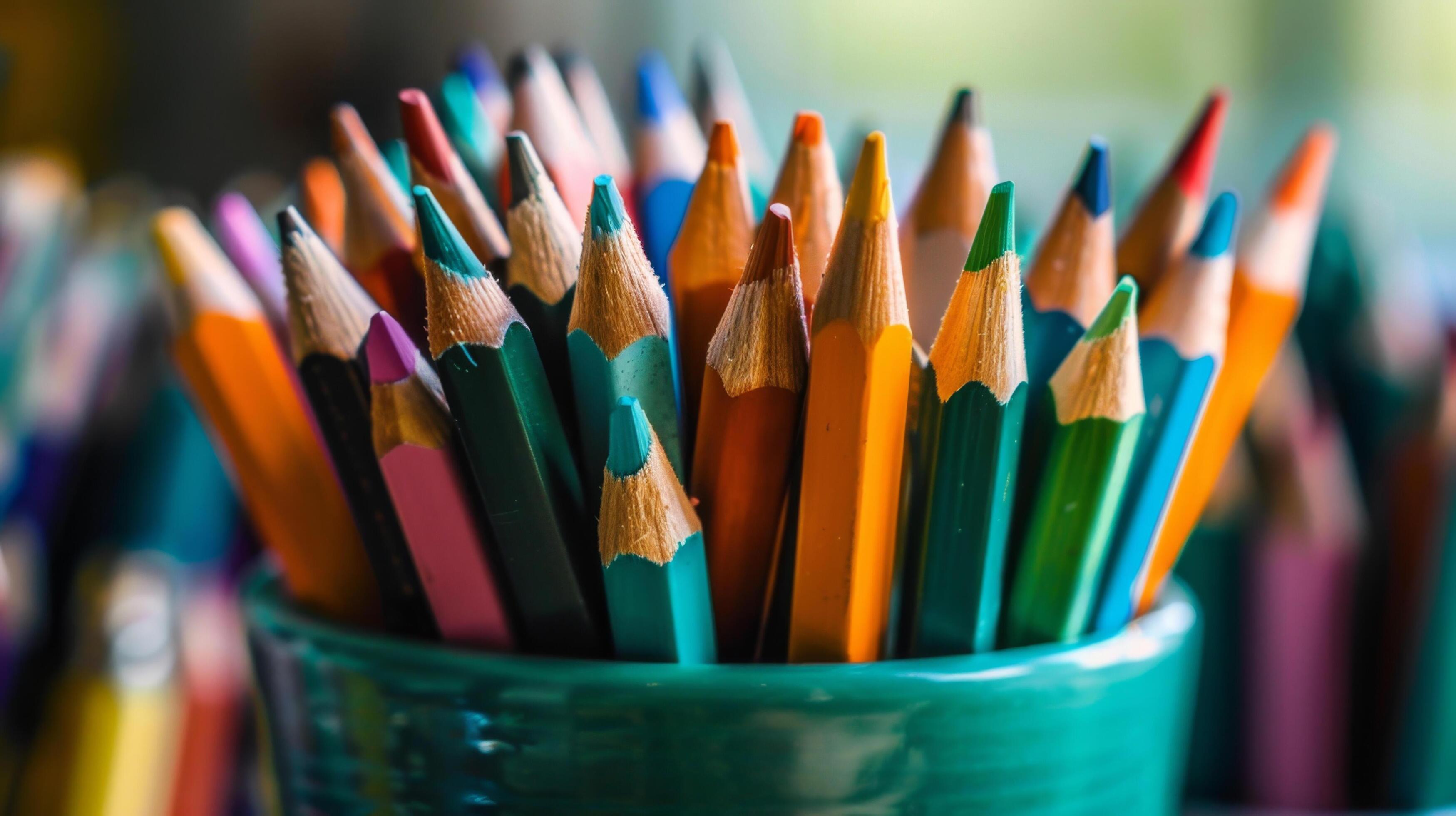 Close-up of colorful pencils in a green pot, perfect for art and education themes. High-resolution image with vibrant colors and sharp details. Stock Free