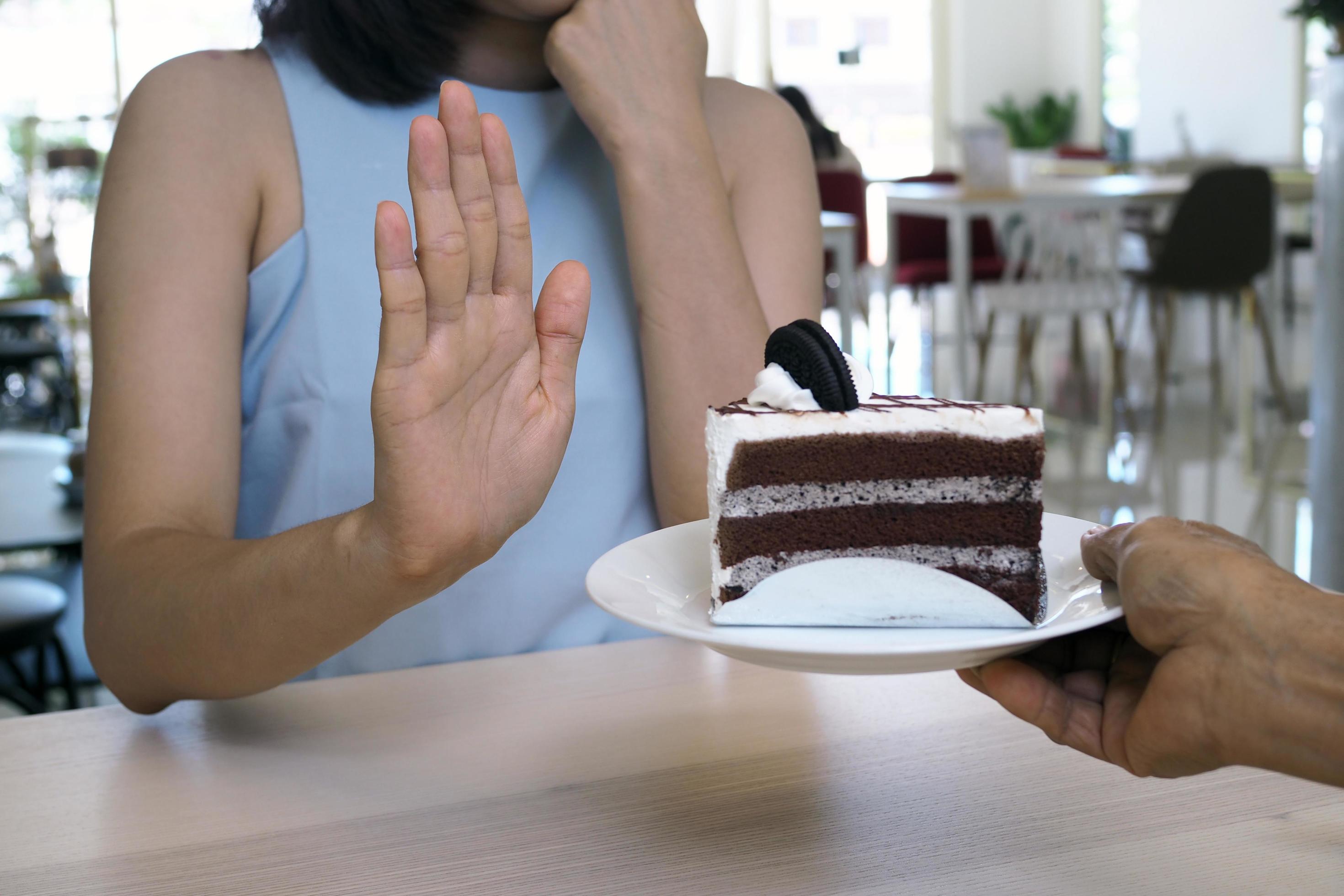 One of the health-care girls used a hand to push a plate of chocolate cake. Refuse to eat foods that contain Trans Fat. Stock Free