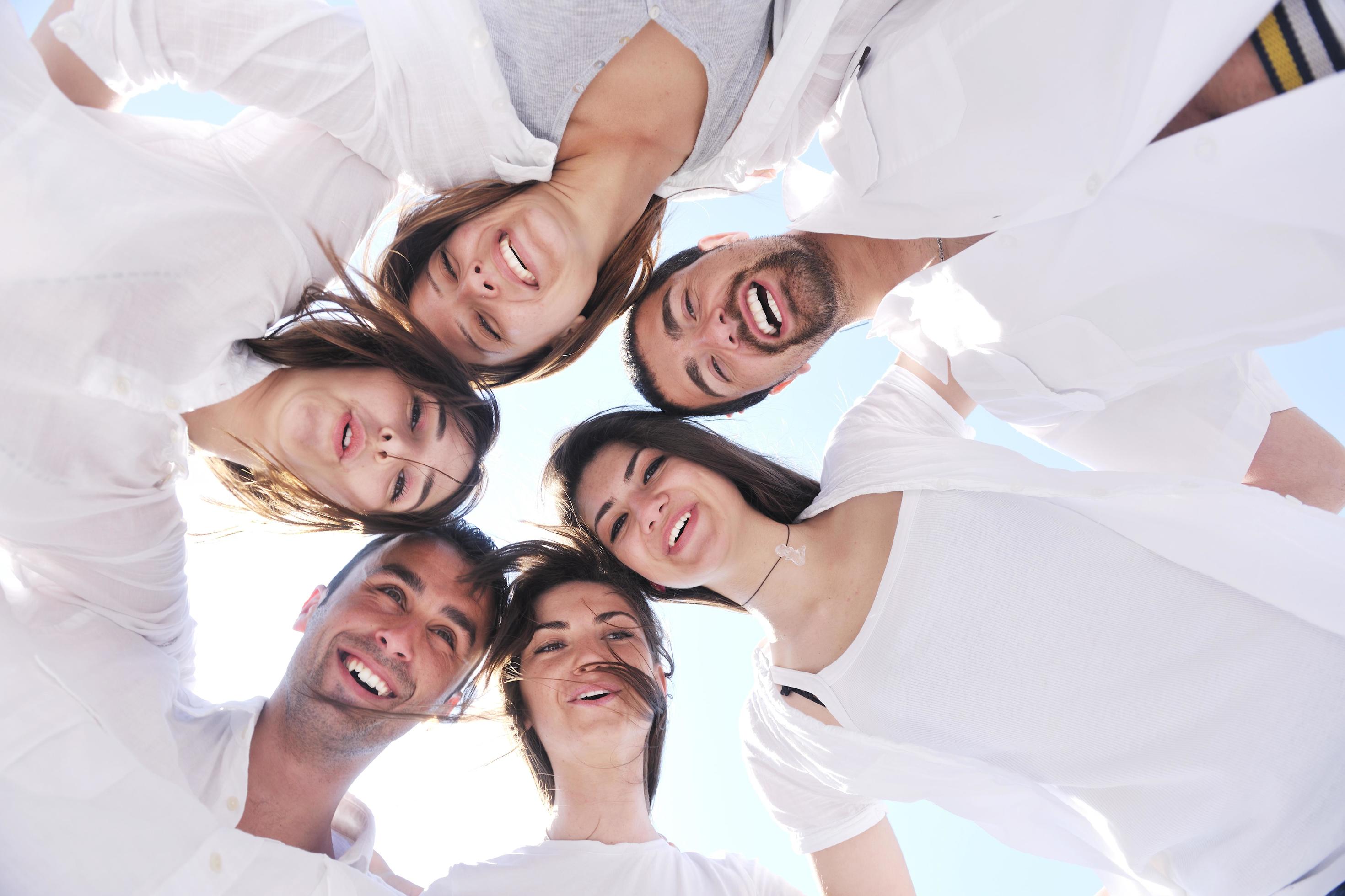 Group of happy young people in circle at beach Stock Free