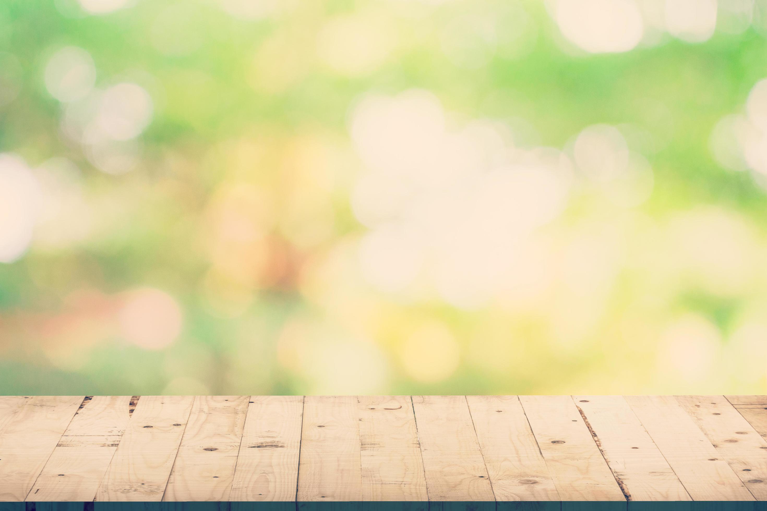 Green leaf bokeh blur and wood table for natural background Stock Free