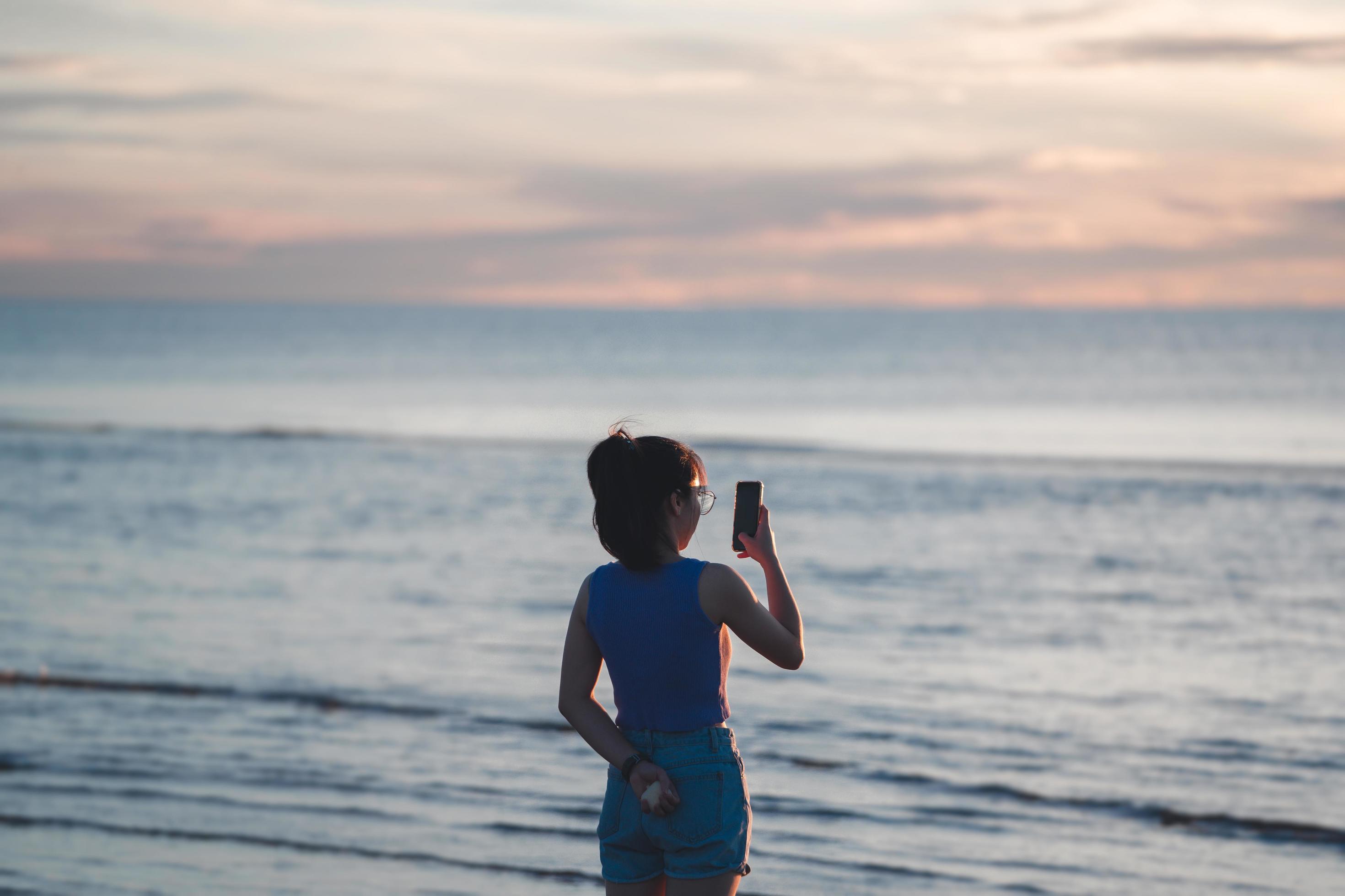 Rear view of young adult travel asian woman relax in nature on beach sea with morning sky Stock Free