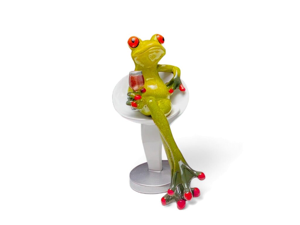 Miniature green frog animal sitting and drinking on a white background Stock Free