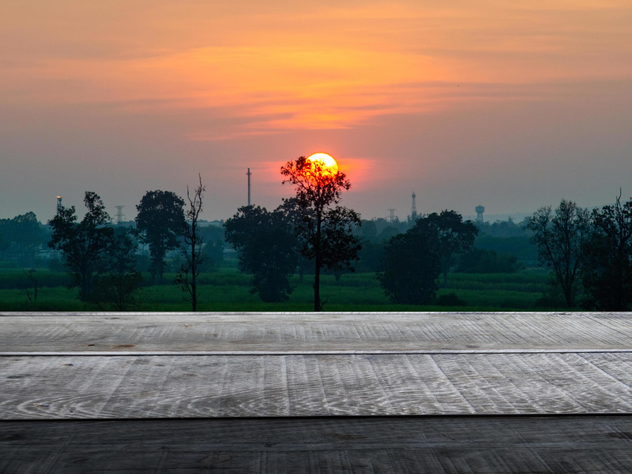 empty wooden table forest nature backdrop orange sky at dusk space for display advertising Stock Free