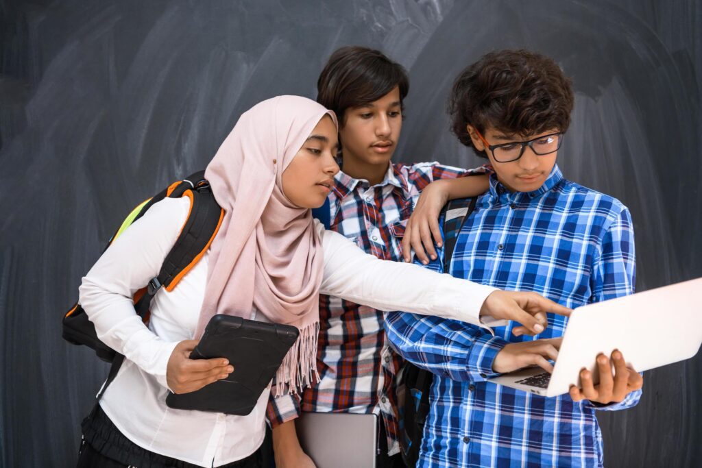 Arabic teenagers team, students group working together on laptop and tablet computer online classroom education concept Stock Free