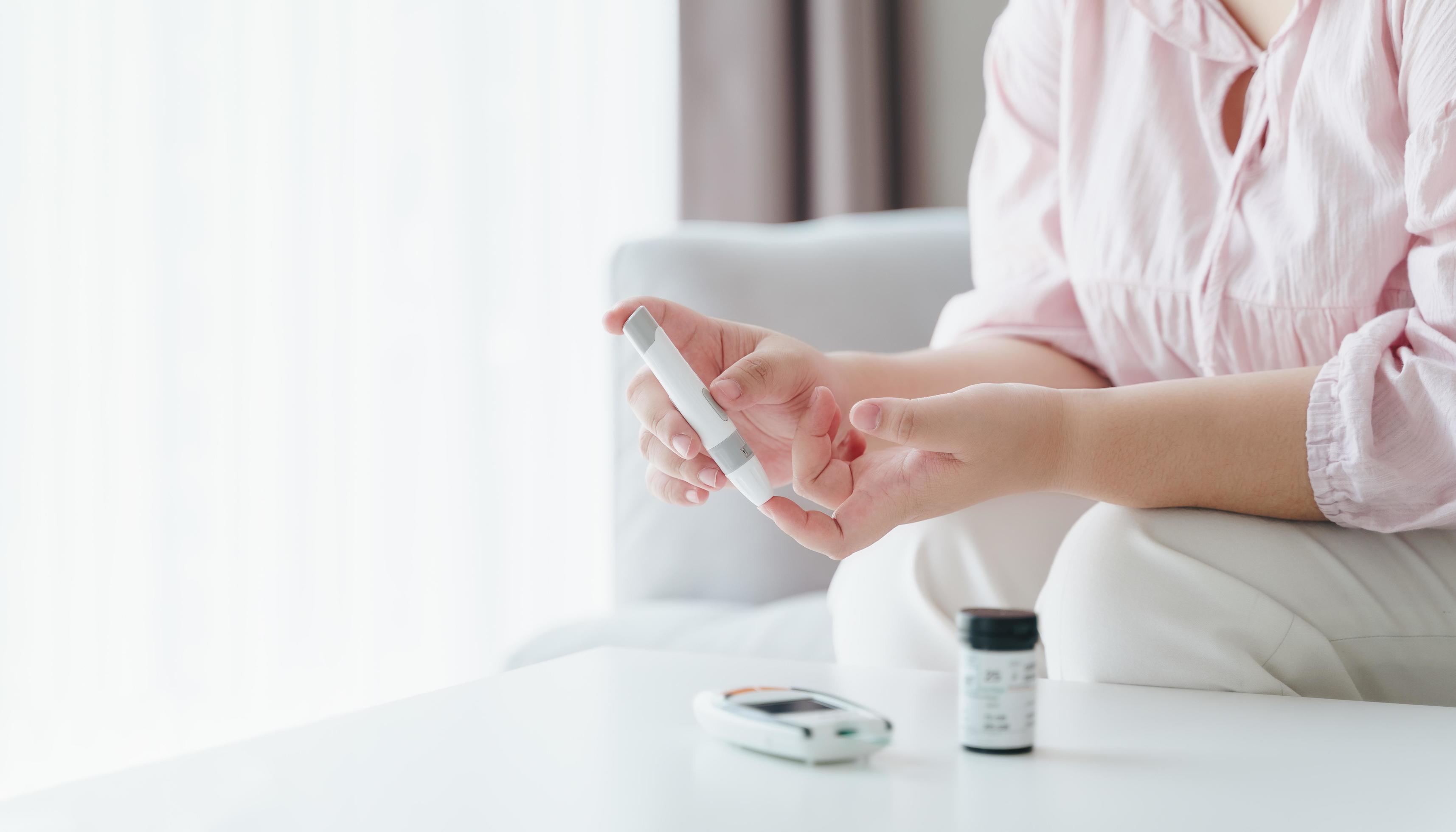 Asian woman using lancet on finger for checking blood sugar level by Glucose meter, Healthcare and Medical, diabetes, glycemia concept Stock Free