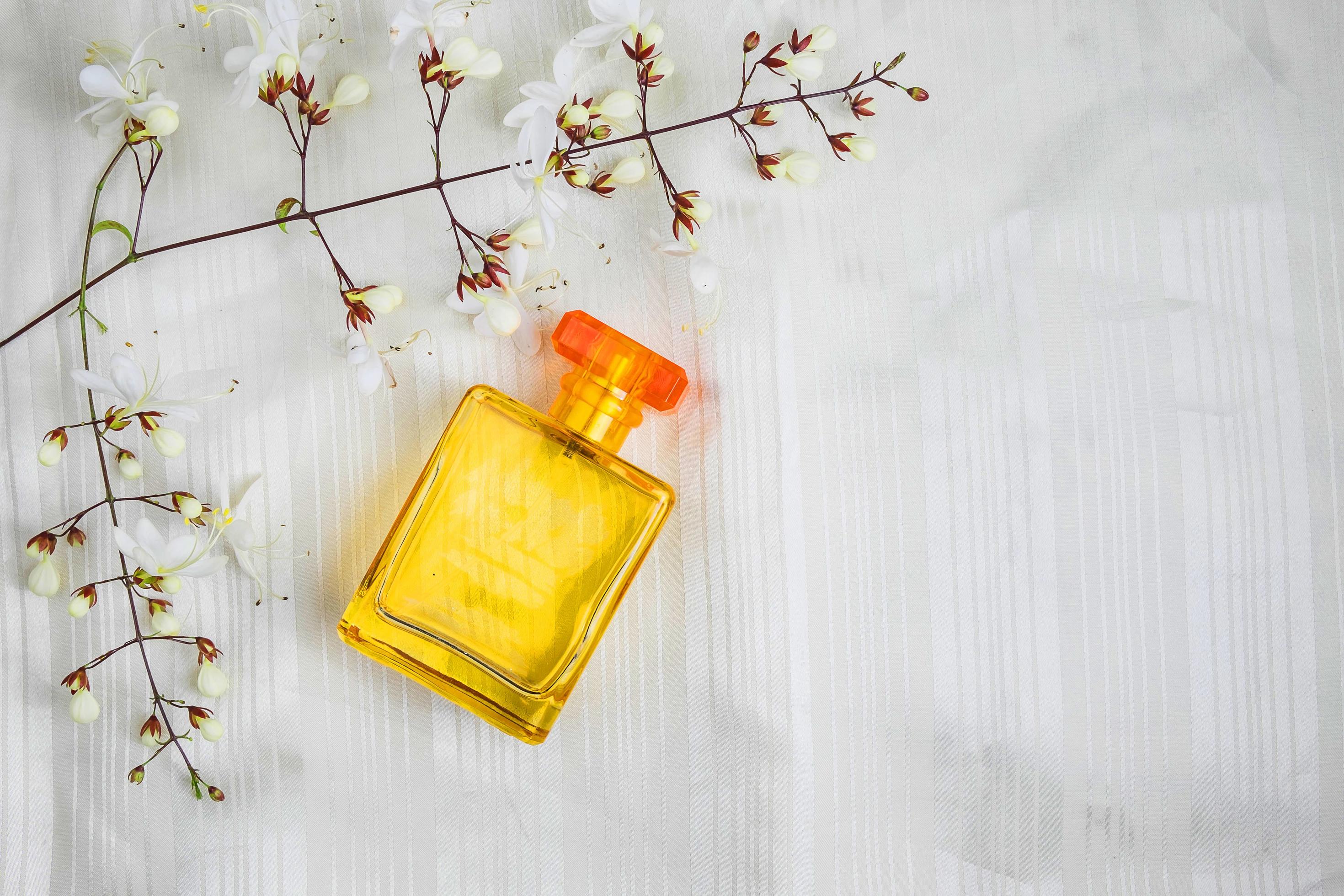 Perfume bottles and flowers on a beautiful white background Stock Free