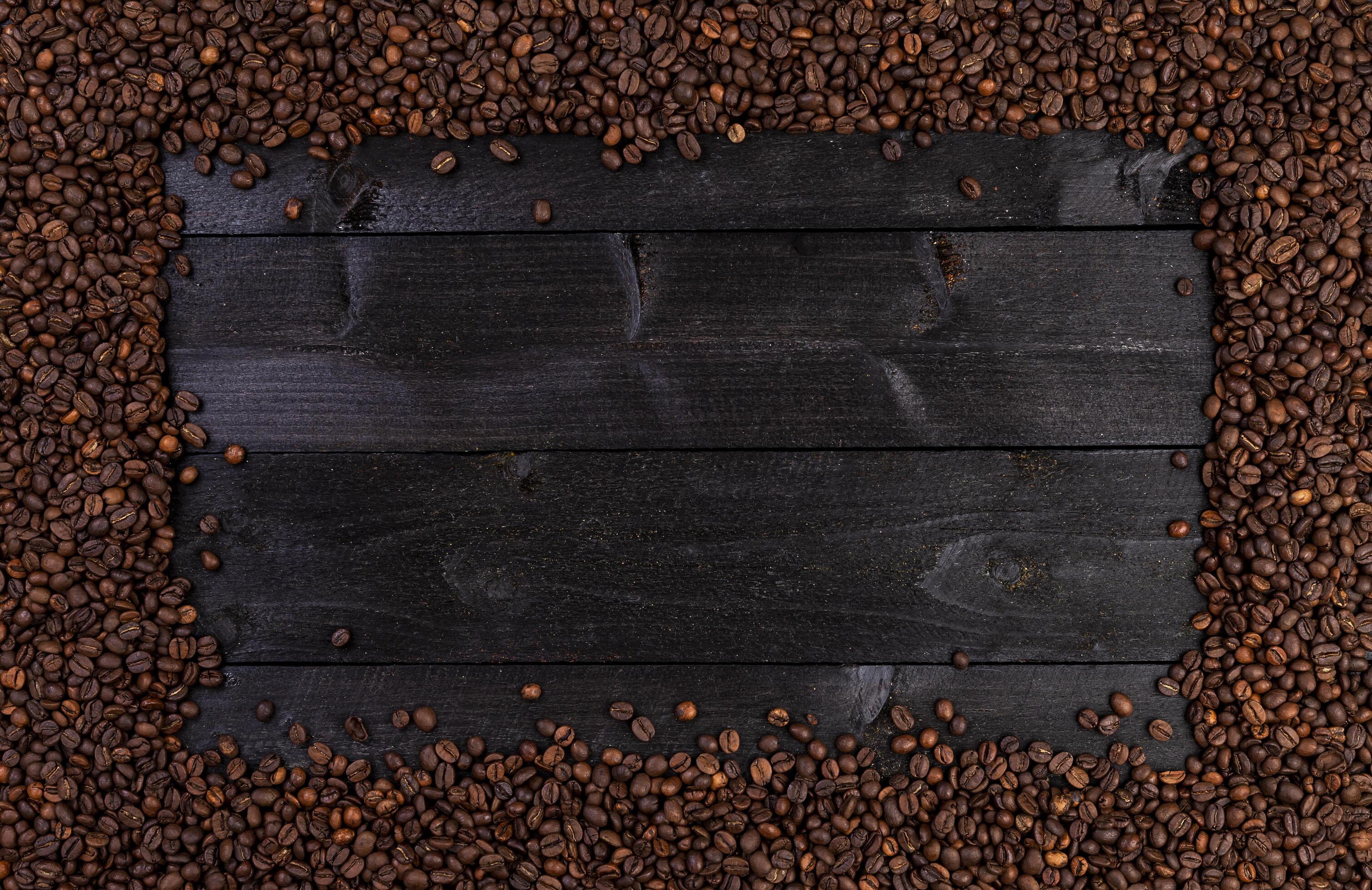 Frame made of roasted coffee beans on black wooden background, top view Stock Free