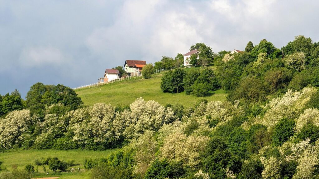 Hillside landscape, house on green hill, mountains in background, Krapina, Croatia, Hrvatsko zagorje Stock Free