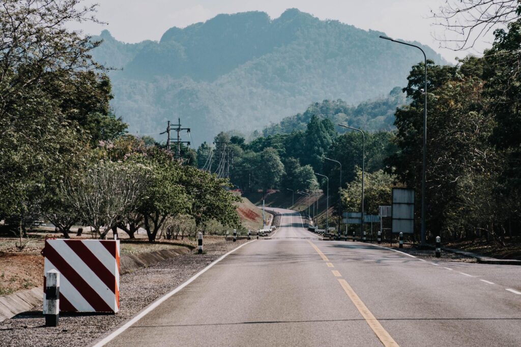 The scene of the road at the dam, with the mountains in the background and a light pole. Stock Free