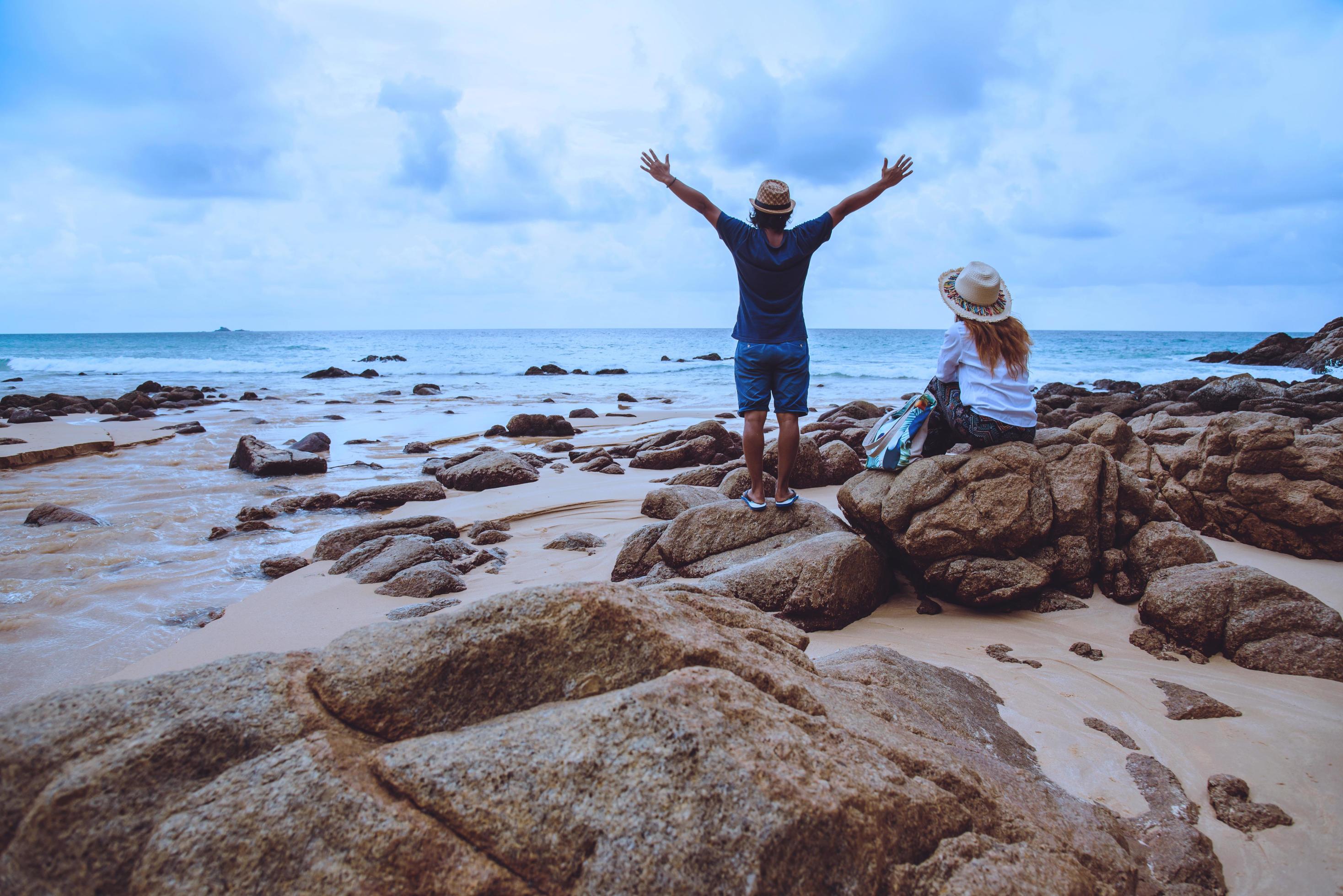 Asian lover woman and man travel nature. Travel relax. On the rocks at the sea. In the summer. Thailand Stock Free