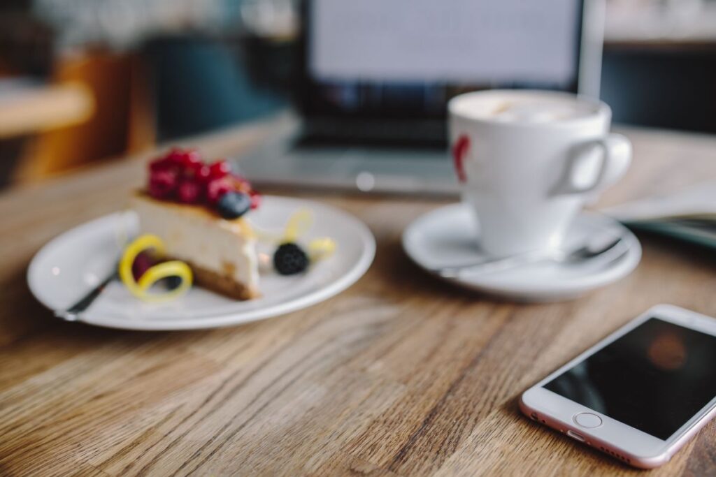 Working in a restaurant: Macbook, Cheese Cake and Cup of Coffee Stock Free