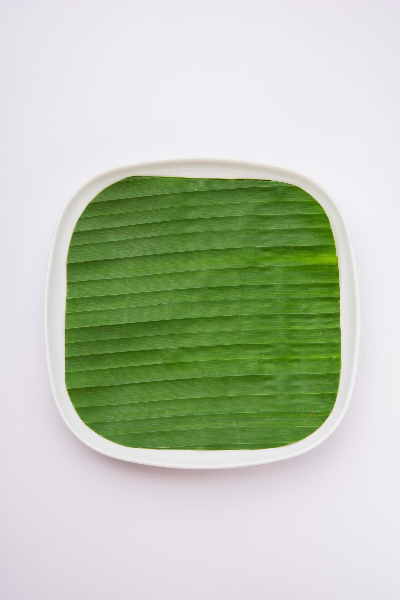 banana leaf on blank plate for edit food or subject on Stock Free