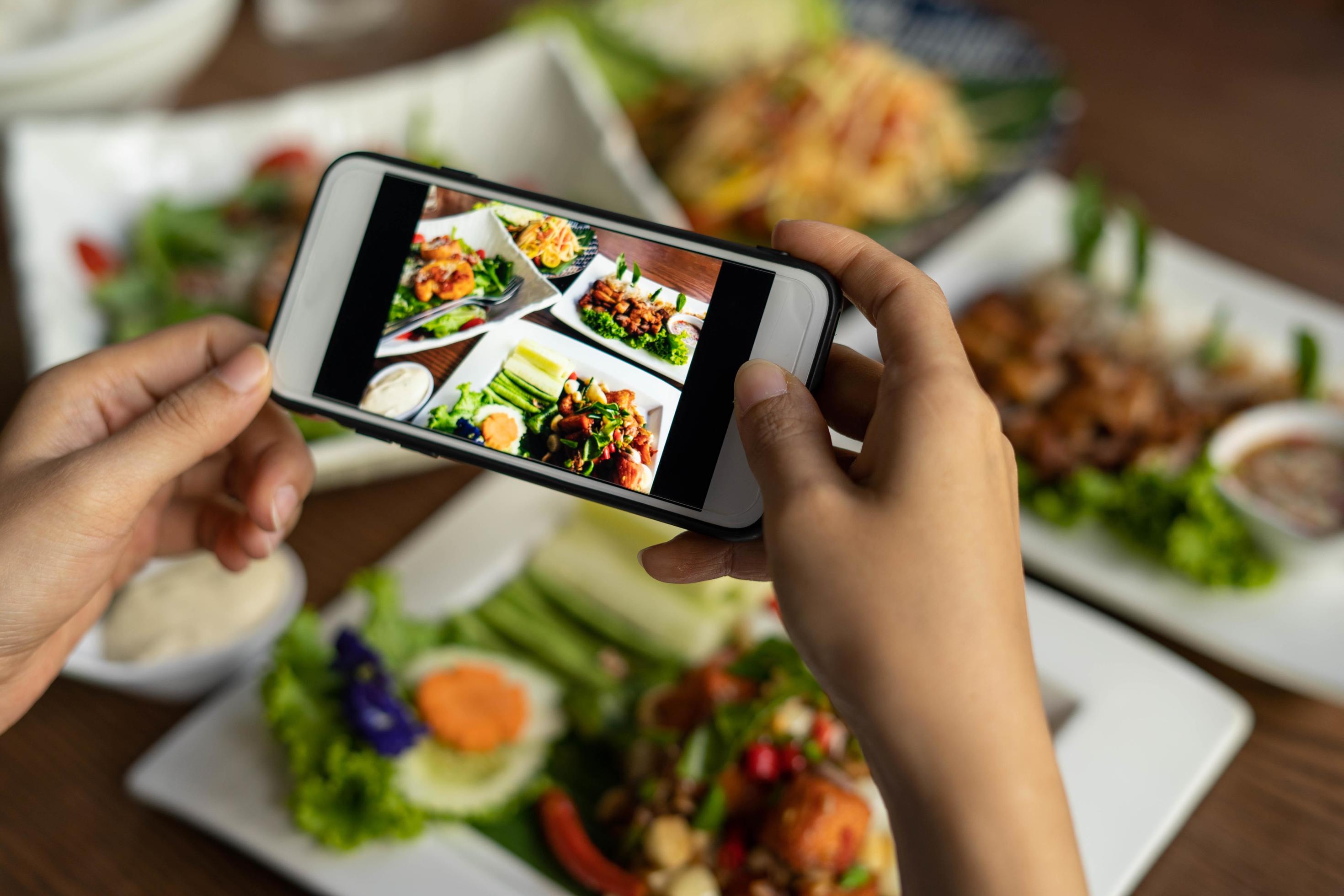 Woman take picture of a meal on the table after ordering food online to eat at home. Photography and use phone concepts Stock Free