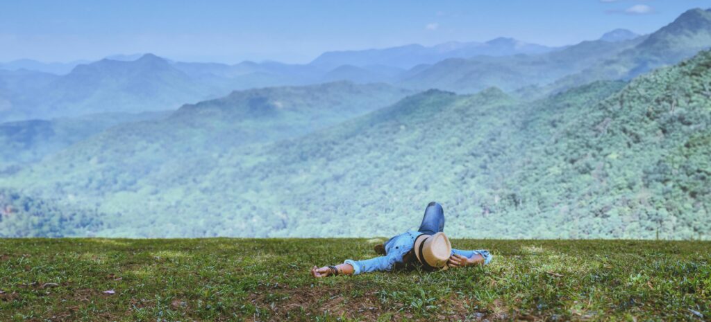 Asian man travel relax in the holiday. Sleep relax on the lawn on the mountain. In Thailand Stock Free