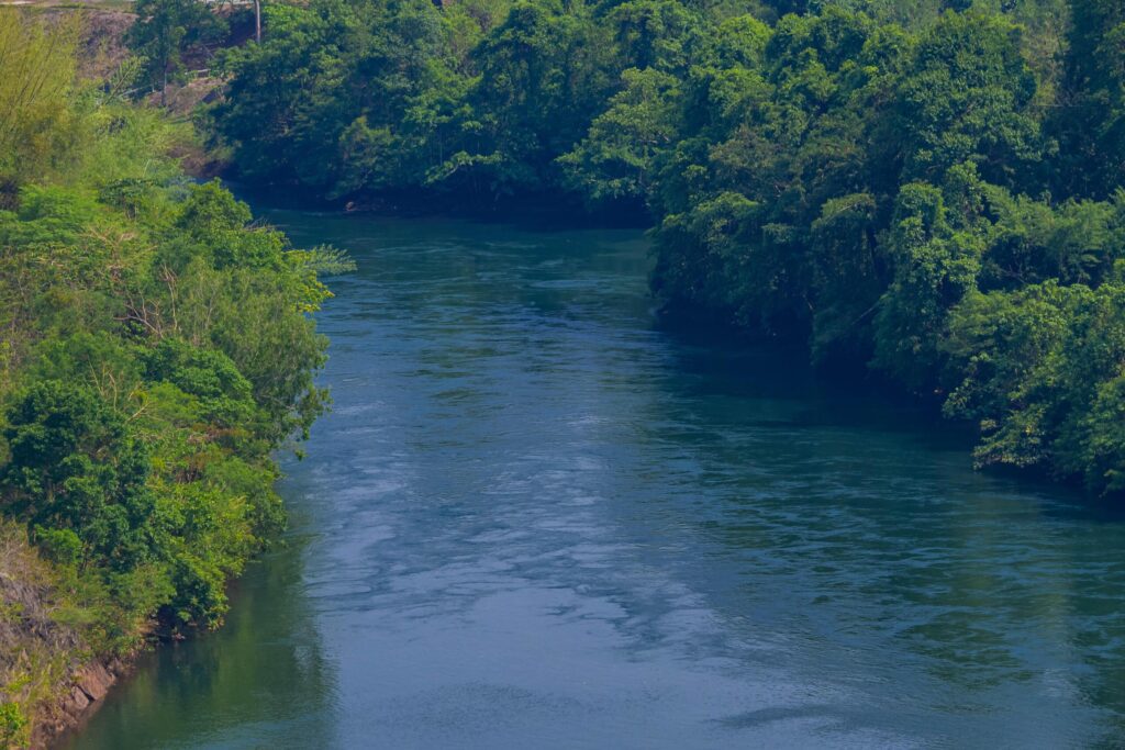 An aerial view of the dam-caused canal in Thailand’s national park, with a mountain the background. Bird eye view. Stock Free